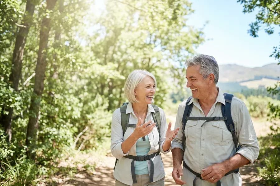 A couple hiking a sunlit trail together